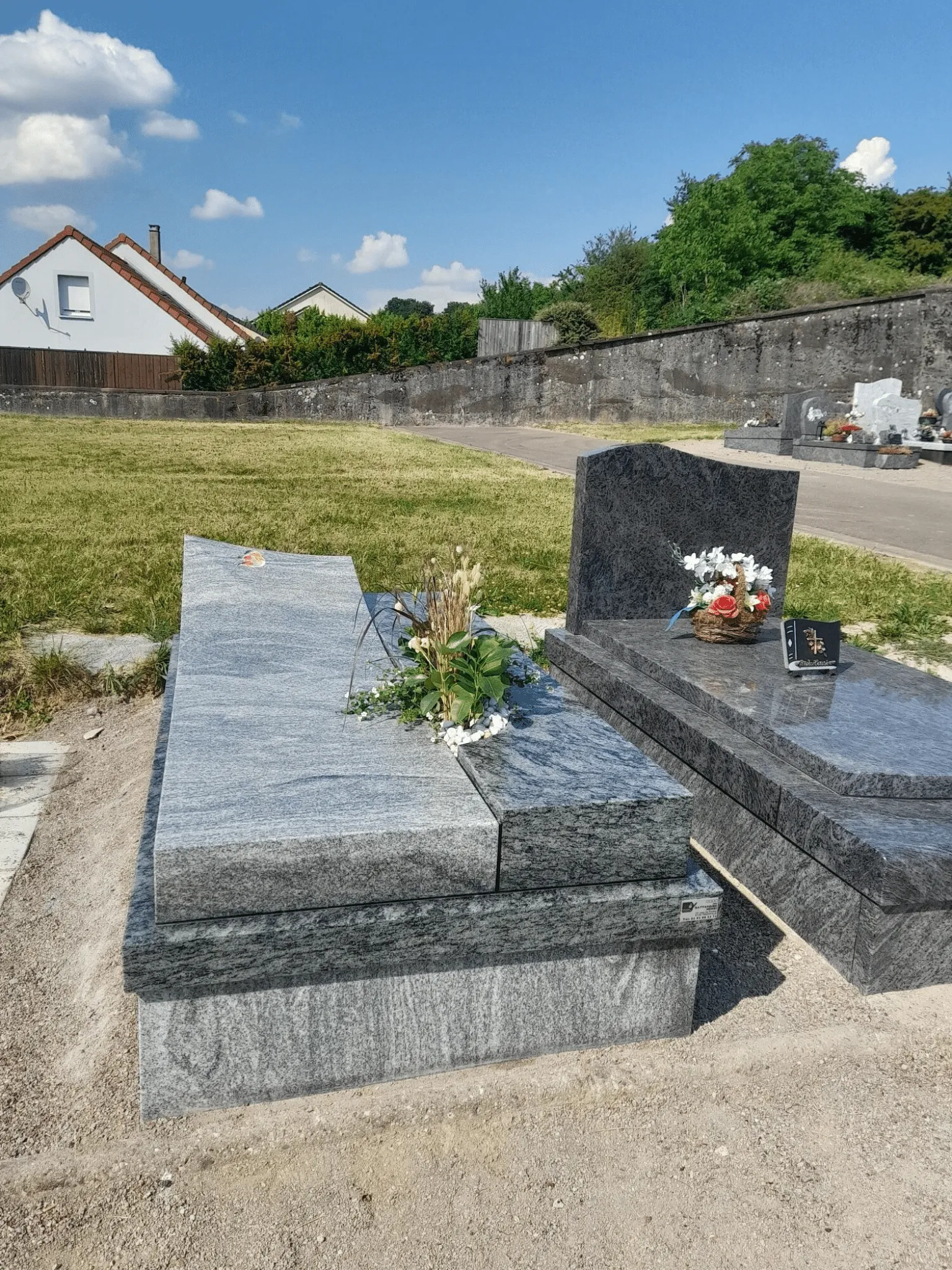 Sépulture en granit gris clair avec pierre tombale biseautée au cimetière